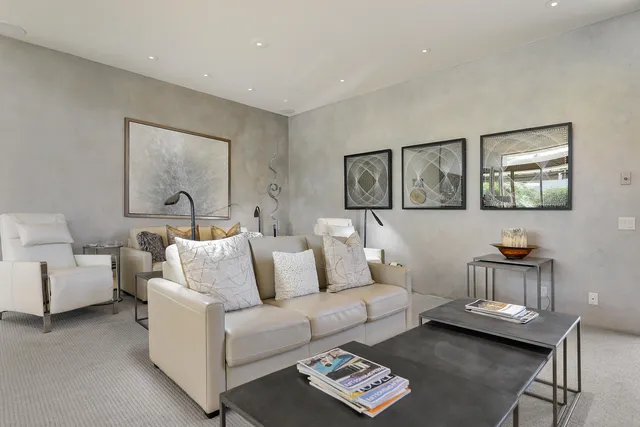 a living room with furniture and painting on the wall