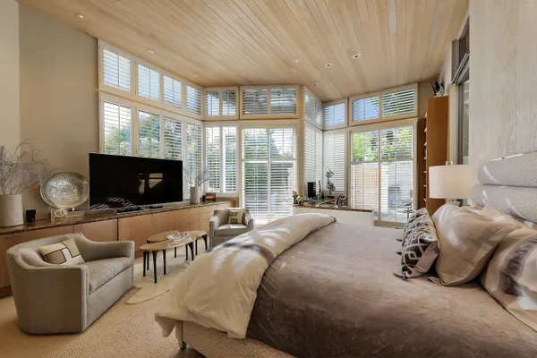 a living room with furniture a flat screen tv and a large window