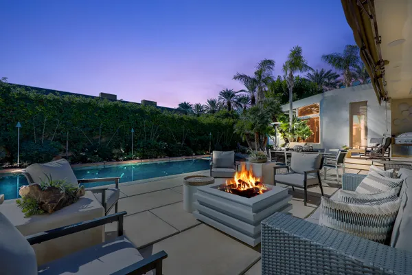 a view of a chairs and tables in the back yard of the house
