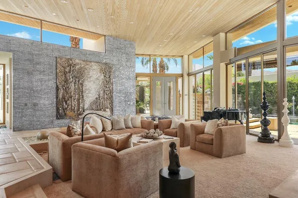 a living room with furniture and large windows