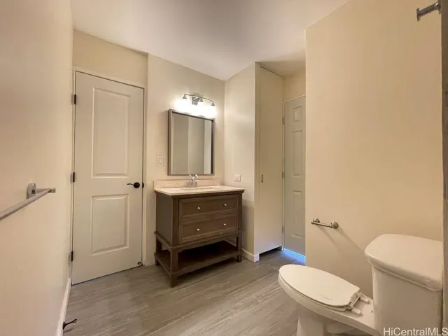 a bathroom with a sink a toilet a mirror and shower