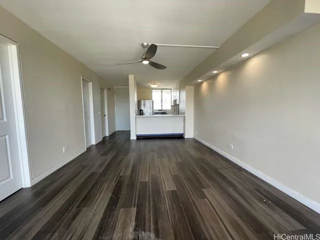a view of a room with wooden floor ceiling fan and window