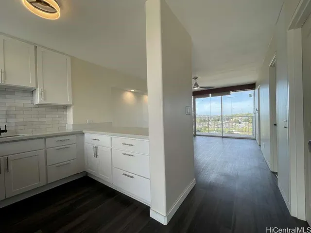 a hallway with white cabinets and wooden floor