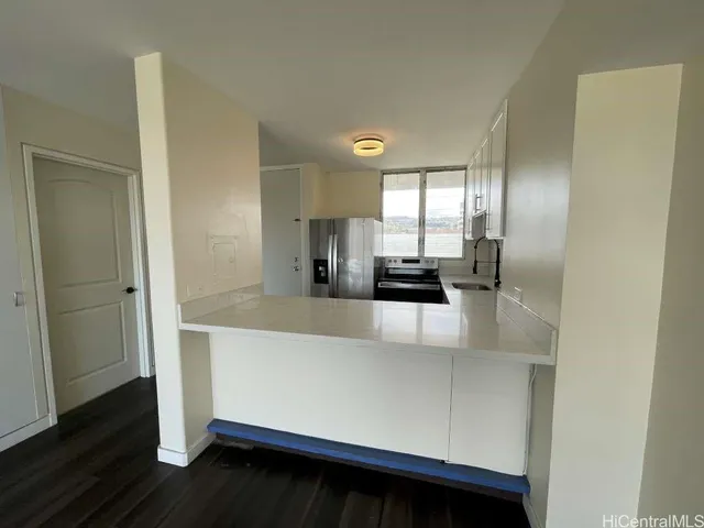 a view of kitchen with stainless steel appliances a refrigerator and wooden floor