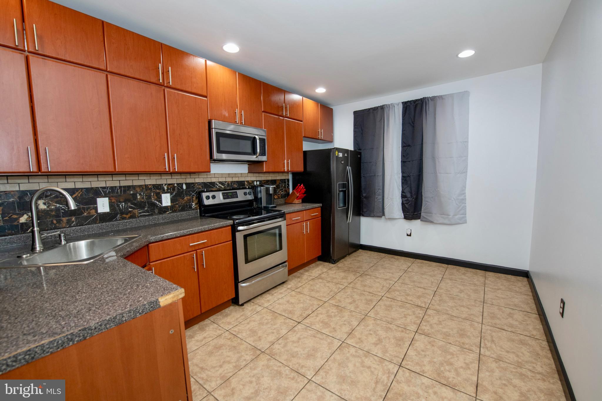 4930 Pulaski Avenue Philadelphia, PA 19144 - Photo 6 of 21 a kitchen with stainless steel appliances granite countertop a refrigerator a stove top oven and sink