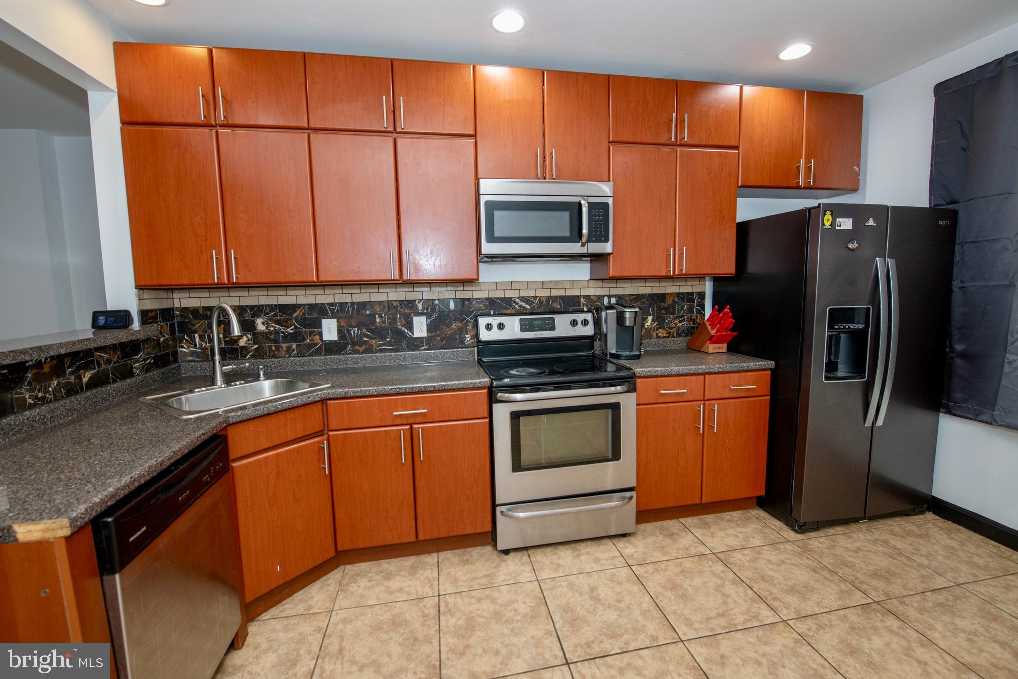 4930 Pulaski Avenue Philadelphia, PA 19144 - Photo 8 of 21 a kitchen with stainless steel appliances granite countertop a stove a sink and a refrigerator