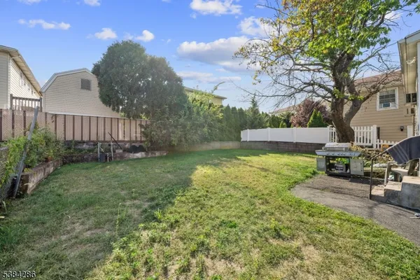 a view of a backyard with couches plants and large trees