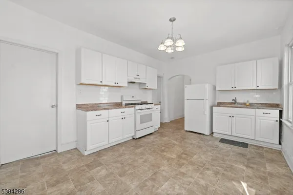 a kitchen with white cabinets and white appliances