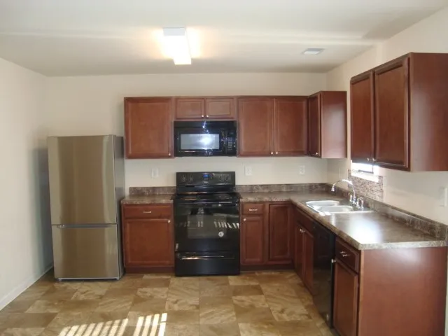 a kitchen with stainless steel appliances granite countertop a refrigerator and a sink