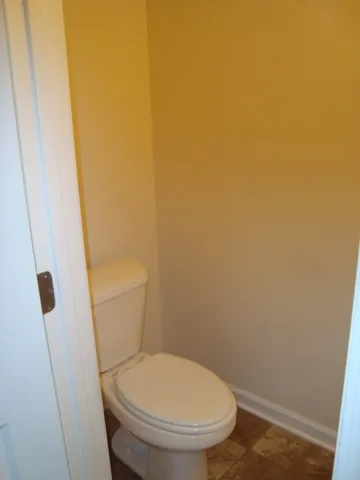 a white toilet sitting next to a shower