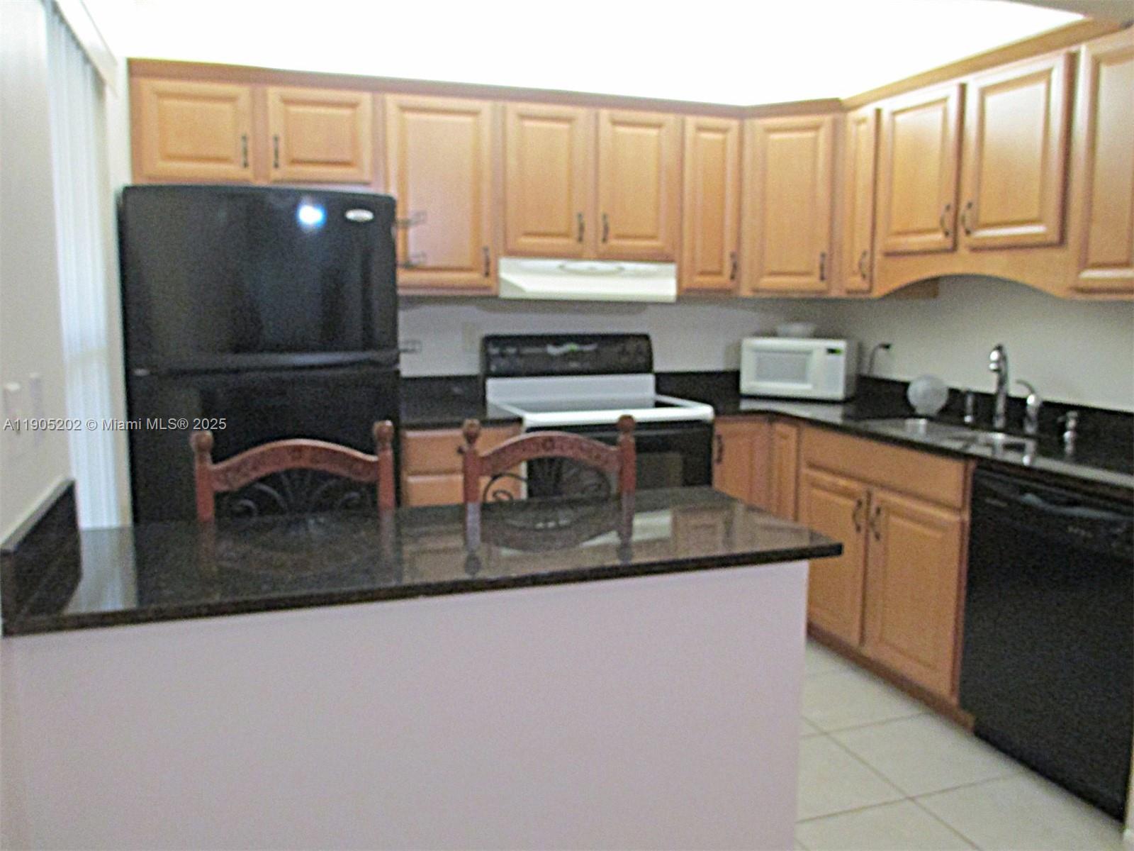 11532 Northwest 10th Street, Unit 11532 Pembroke Pines, FL 33026 - Photo 14 of 16 a kitchen with stainless steel appliances granite countertop a sink a stove and cabinets