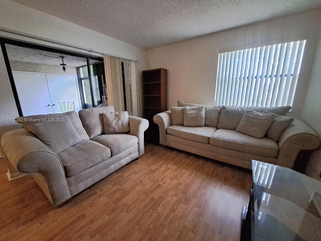 11532 Northwest 10th Street, Unit 11532 Pembroke Pines, FL 33026 - Photo 2 of 16 a living room with furniture and a couch