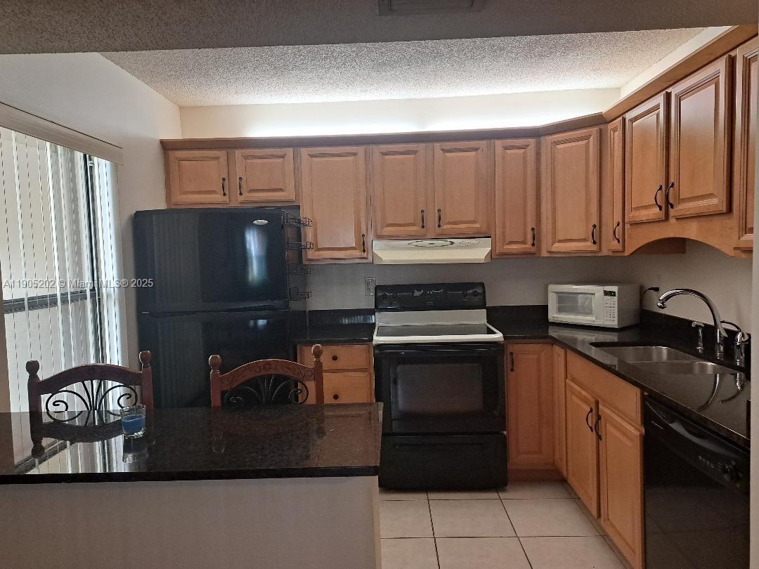 11532 Northwest 10th Street, Unit 11532 Pembroke Pines, FL 33026 - Photo 4 of 16 a kitchen with a sink cabinets and stainless steel appliances
