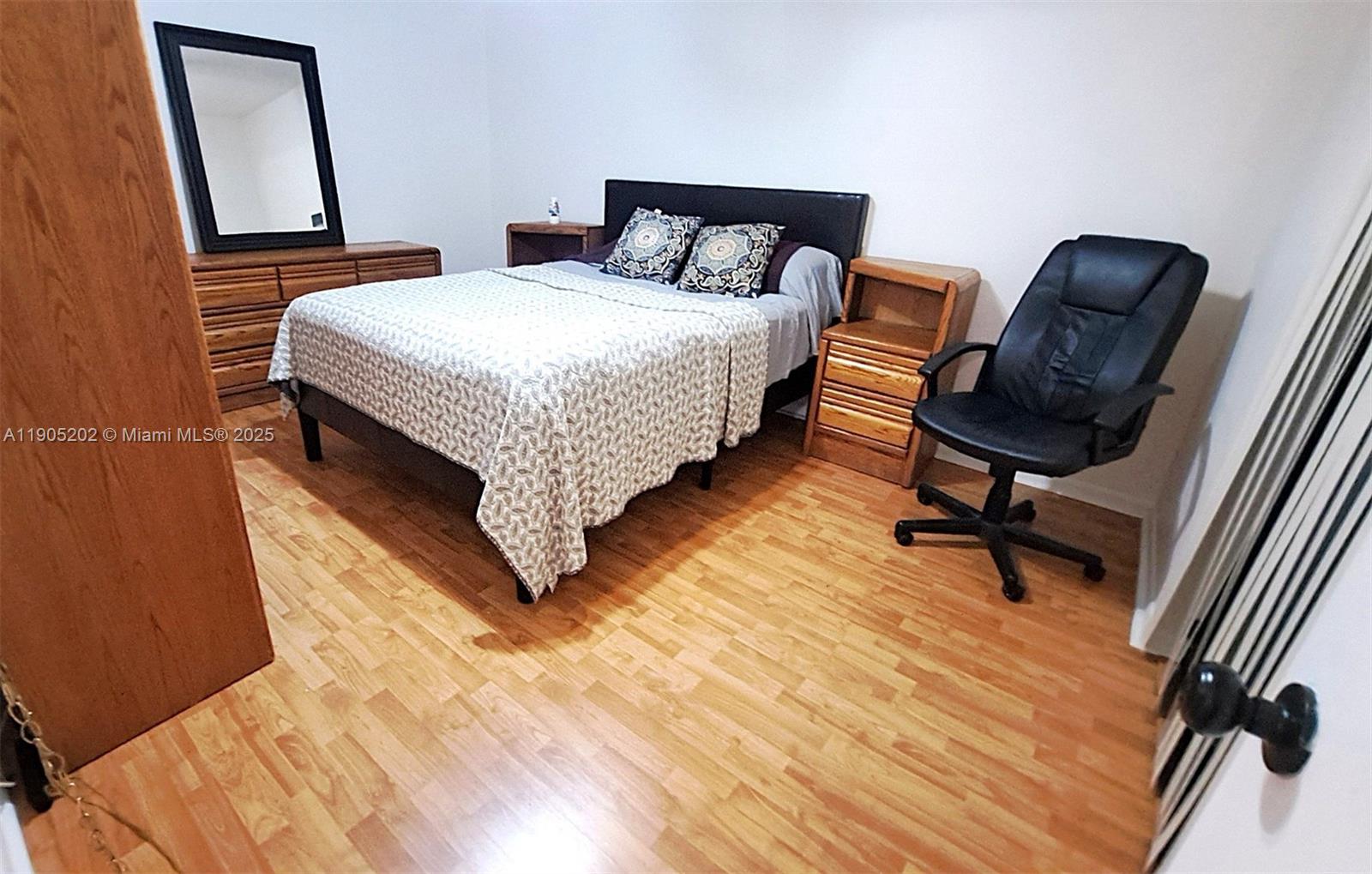 11532 Northwest 10th Street, Unit 11532 Pembroke Pines, FL 33026 - Photo 5 of 16 a bedroom with a bed a mirror and a dresser