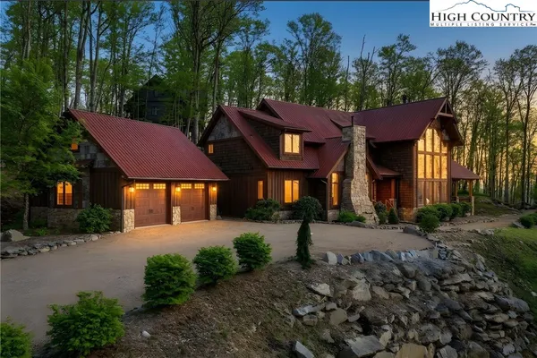 a front view of a house with a yard and a tree