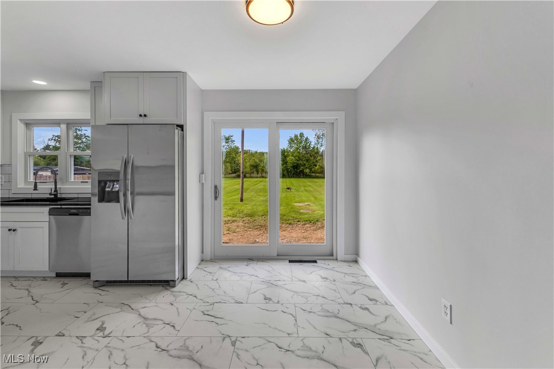 7843 Stone Road Medina, OH 44256 - Photo 12 of 27 Kitchen with appliances with stainless steel finishes, a sink, light marble finish flooring, dark countertops, and recessed lighting