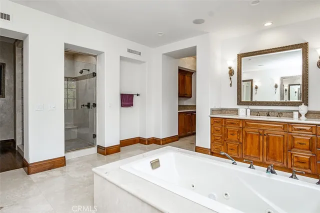 a spacious bathroom with stainless steel appliances double vanity and windows