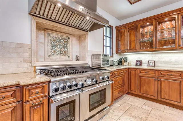 a kitchen with stainless steel appliances granite countertop a stove sink and cabinets