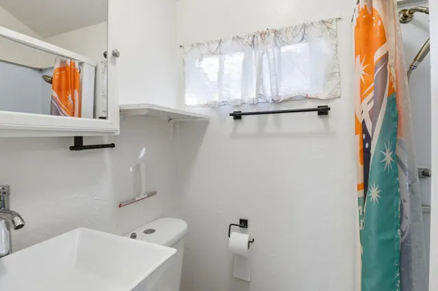 a bathroom with a sink a window and a shower