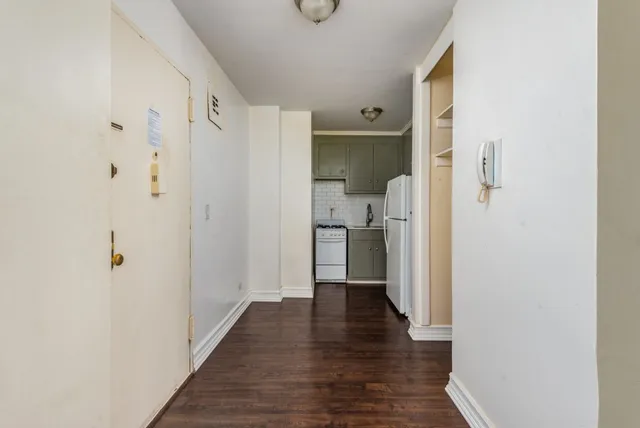 a view of a hallway with wooden floor and cabinet