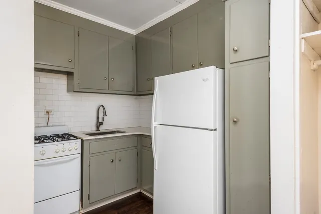 a white refrigerator freezer and a stove sitting inside of a kitchen