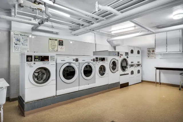a utility room with stainless steel appliances and white cabinets
