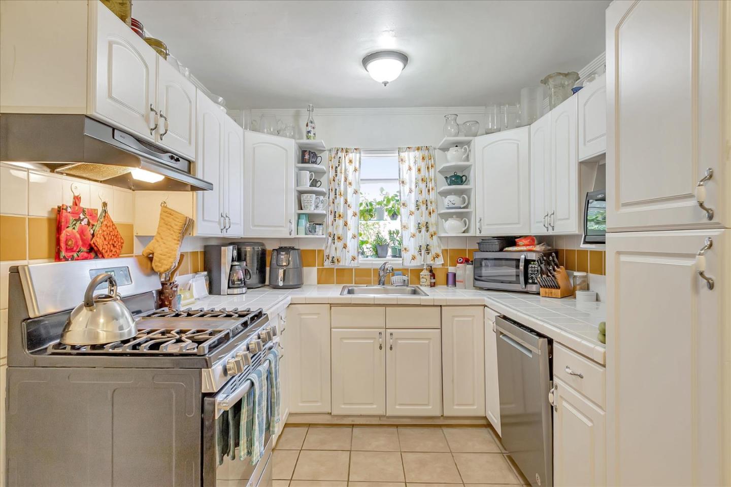 22620 Alcalde Road Cupertino, CA 95014 - Photo 14 of 39 a kitchen with stainless steel appliances a white stove top oven a sink a counter space and cabinets