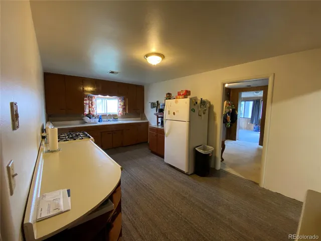 a kitchen view with wooden floor and refrigerator