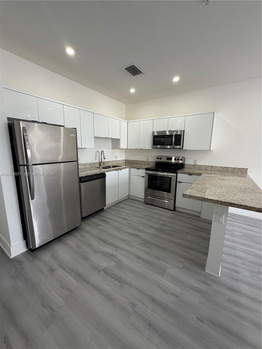 853 East 24th Street, Unit 203 Hialeah, FL 33013 - Photo 4 of 13 a kitchen with stainless steel appliances granite countertop a refrigerator stove a sink and a oven