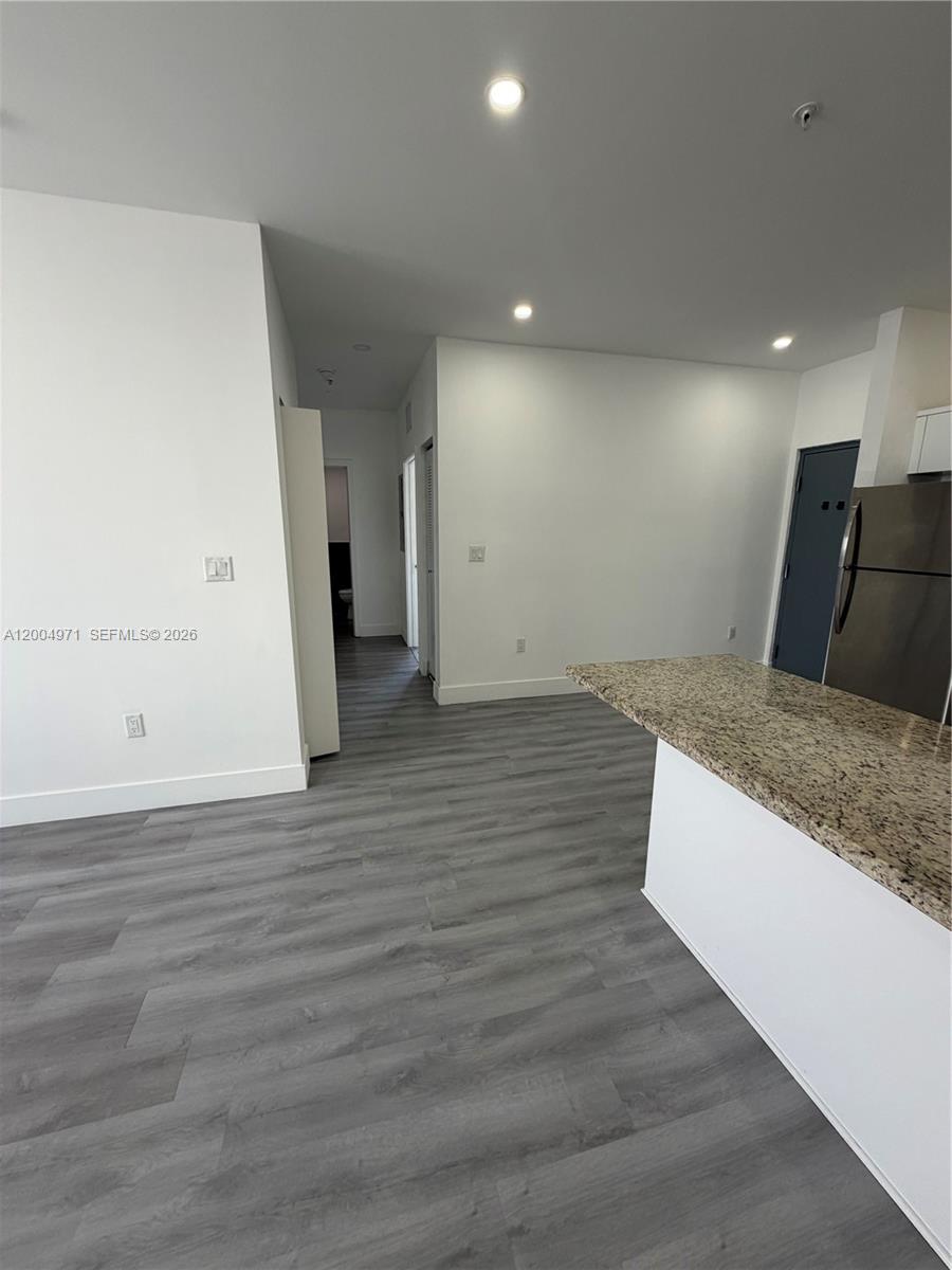 853 East 24th Street, Unit 203 Hialeah, FL 33013 - Photo 5 of 13 an empty room with wooden floor and entrance