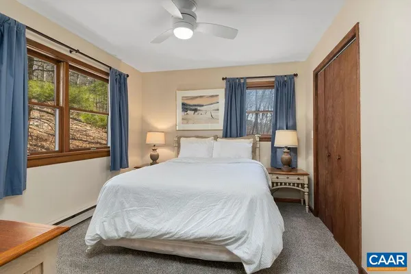 a bed sitting in a bedroom next to a window with dresser