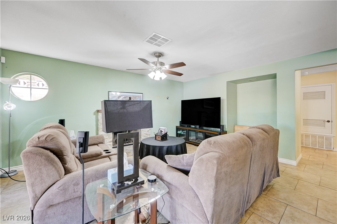 14 Barton Spring Circle Henderson, NV 89074 - Photo 16 of 64 Living room featuring light tile patterned floors and ceiling fan