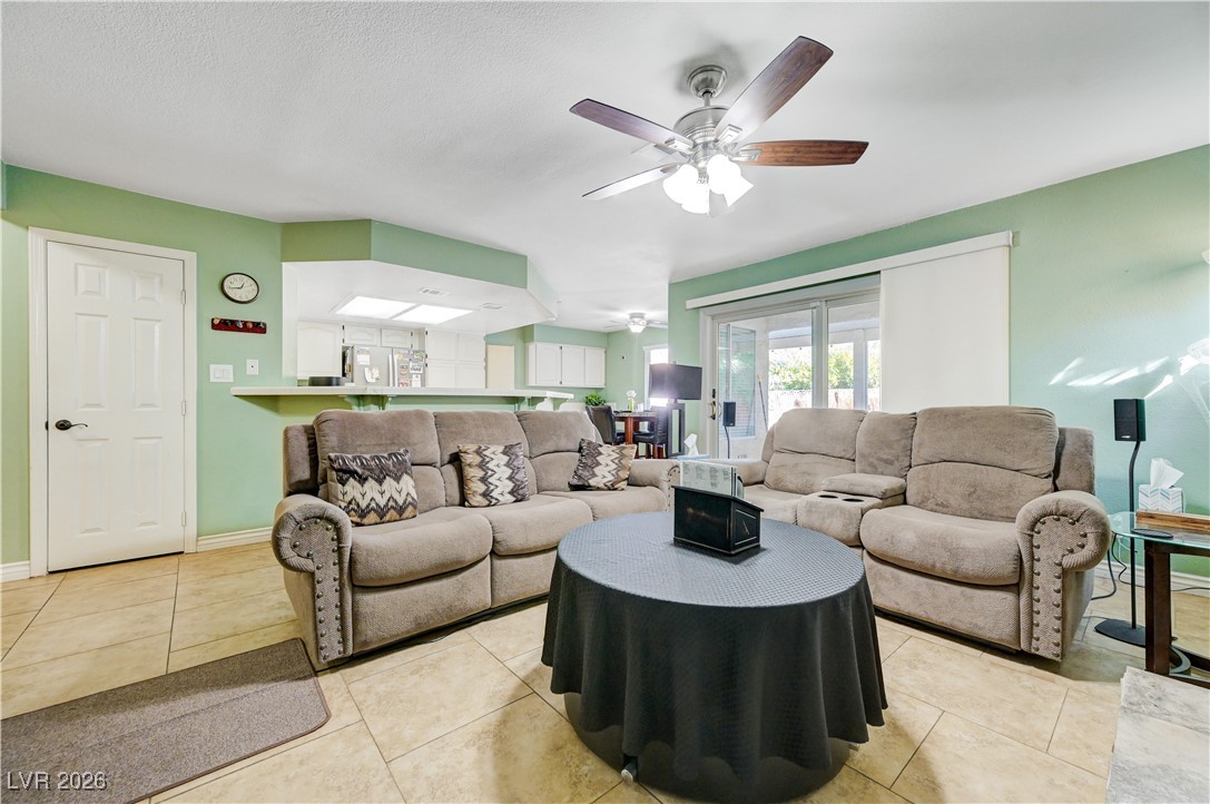 14 Barton Spring Circle Henderson, NV 89074 - Photo 18 of 64 Living area with ceiling fan and light tile patterned floors