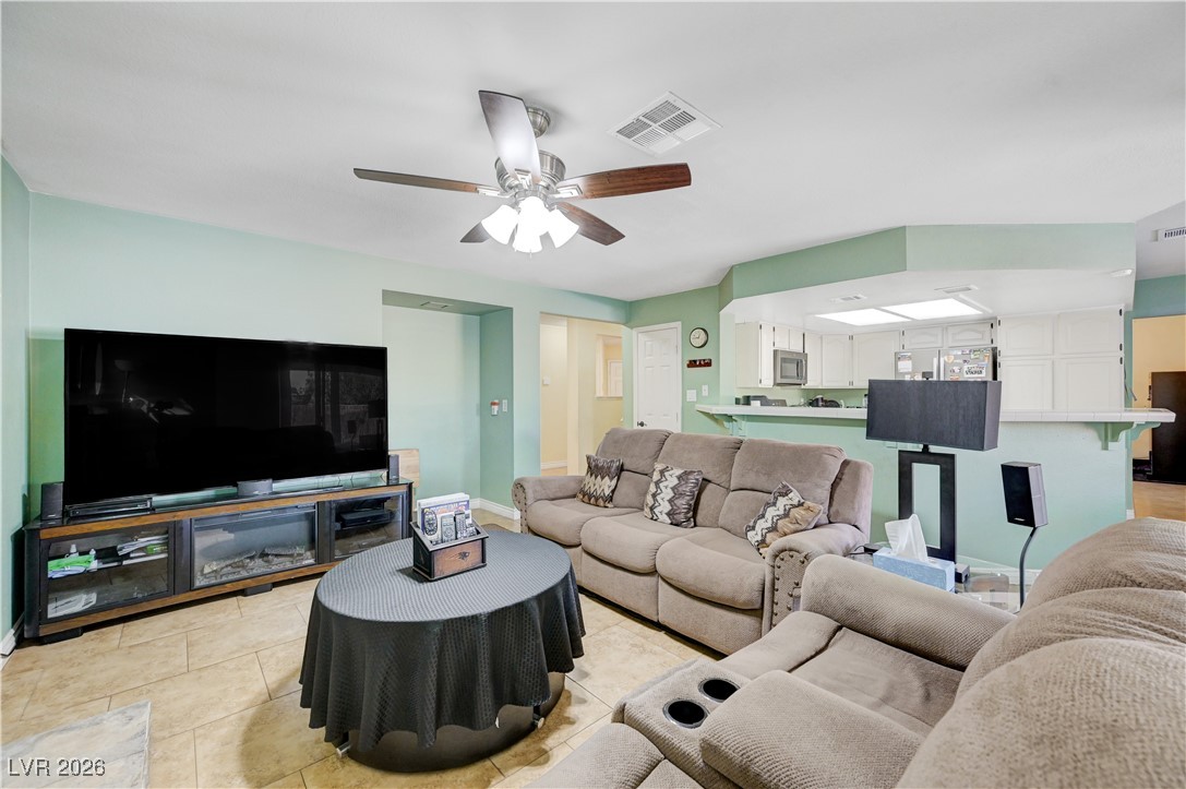 14 Barton Spring Circle Henderson, NV 89074 - Photo 19 of 64 Living room featuring ceiling fan and light tile patterned floors