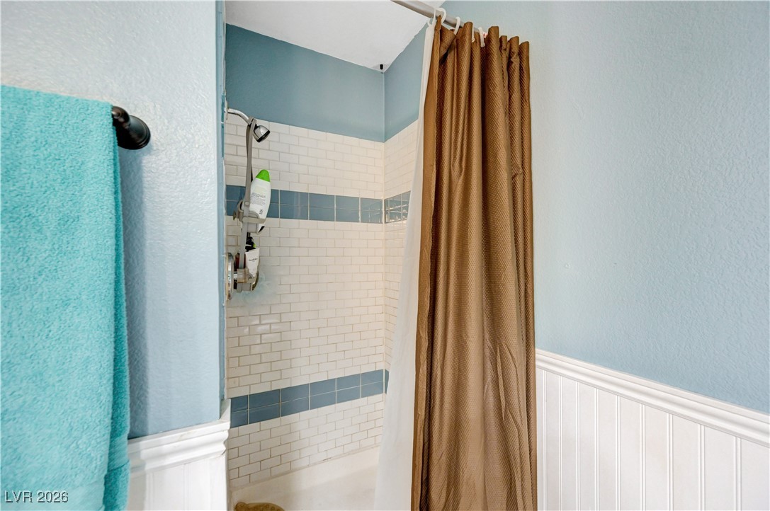 14 Barton Spring Circle Henderson, NV 89074 - Photo 22 of 64 Bathroom featuring a wainscoted wall, a shower stall, and a textured wall