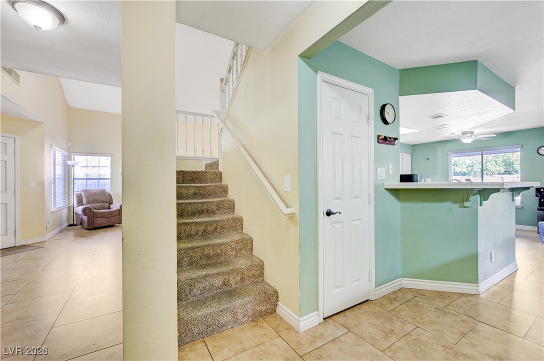 14 Barton Spring Circle Henderson, NV 89074 - Photo 25 of 64 Staircase with ceiling fan and tile patterned flooring