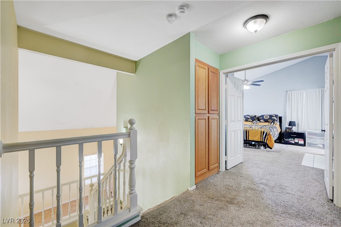 14 Barton Spring Circle Henderson, NV 89074 - Photo 26 of 64 Corridor featuring light carpet, an upstairs landing, and lofted ceiling