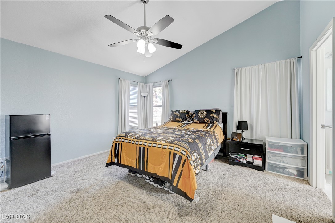 14 Barton Spring Circle Henderson, NV 89074 - Photo 28 of 64 Bedroom with vaulted ceiling, freestanding refrigerator, carpet floors, and a ceiling fan