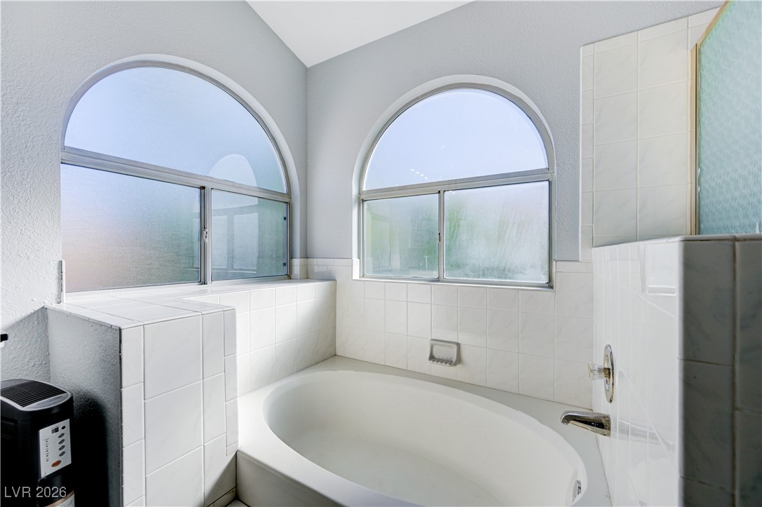 14 Barton Spring Circle Henderson, NV 89074 - Photo 33 of 64 Bathroom featuring a garden tub and a textured wall