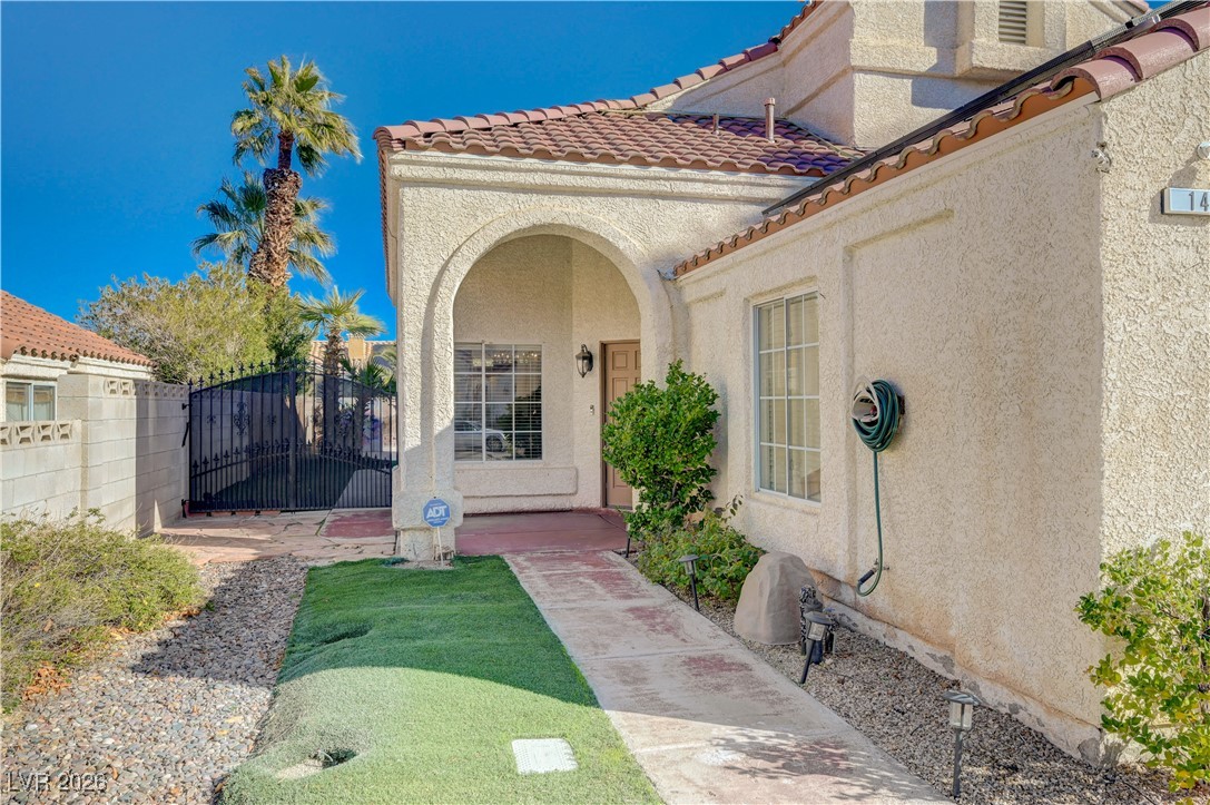14 Barton Spring Circle Henderson, NV 89074 - Photo 5 of 64 Doorway to property featuring stucco siding, a gate, and a tiled roof