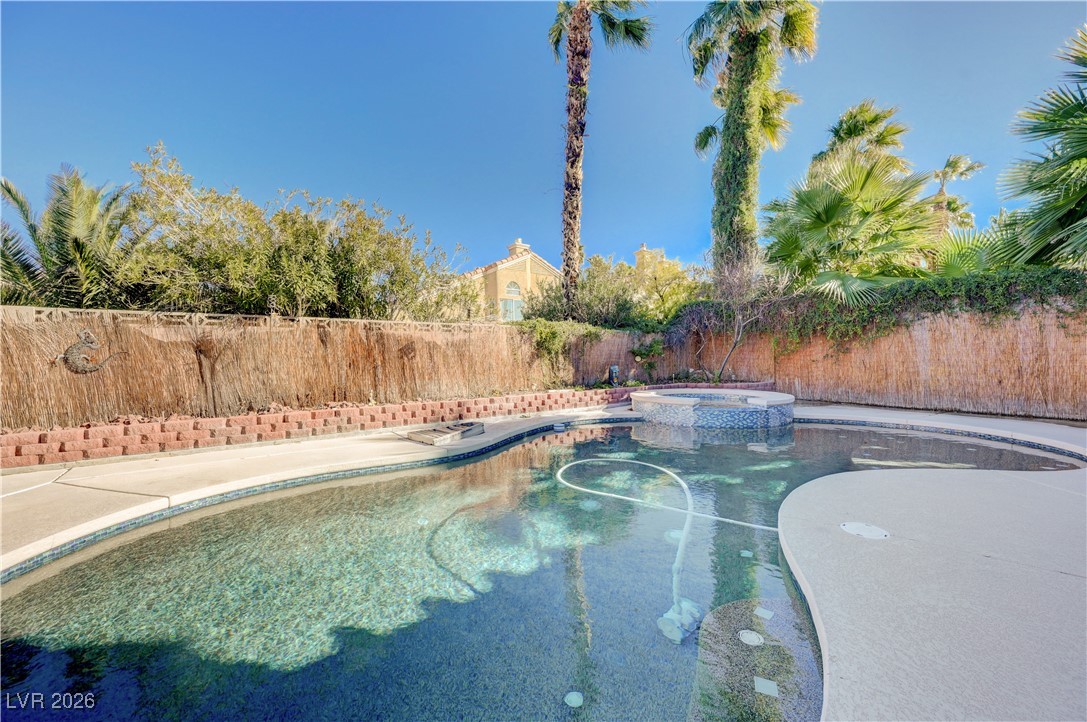 14 Barton Spring Circle Henderson, NV 89074 - Photo 51 of 64 View of pool featuring a pool with connected hot tub, a fenced backyard, and a patio