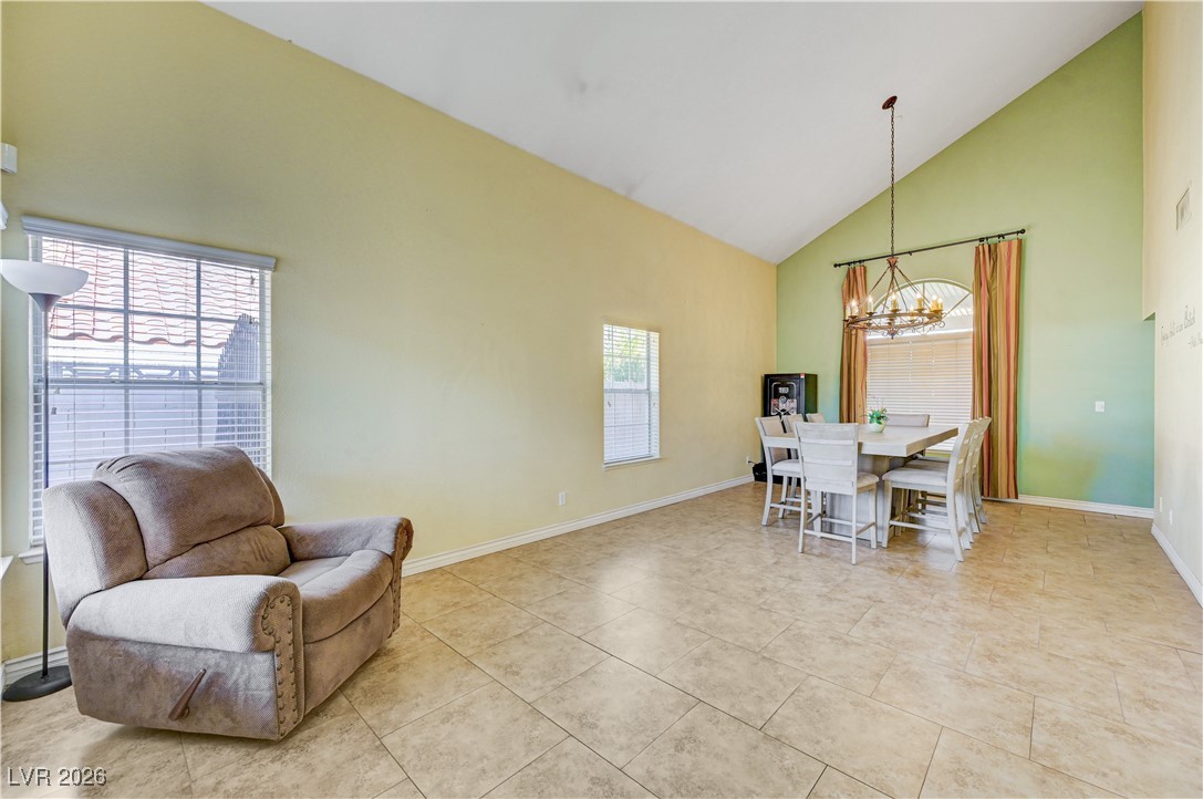 14 Barton Spring Circle Henderson, NV 89074 - Photo 6 of 64 Dining area with high vaulted ceiling, a chandelier, and light tile patterned floors