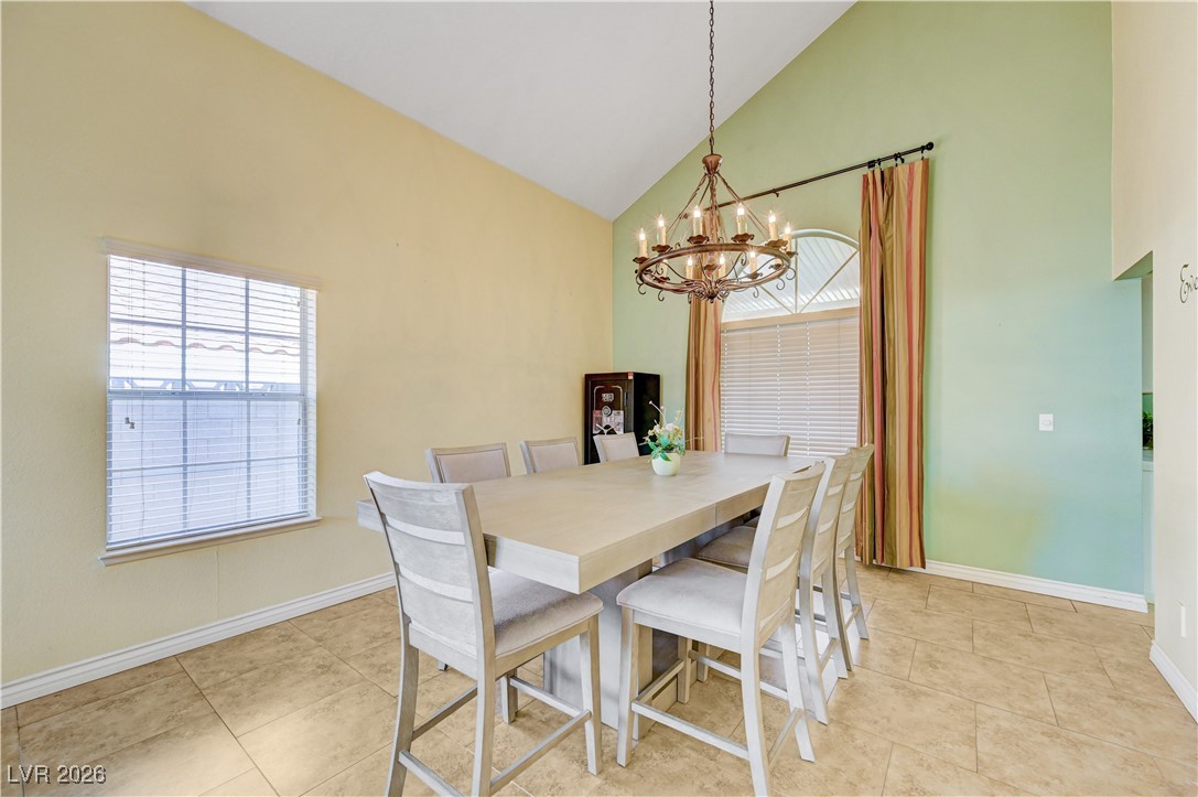 14 Barton Spring Circle Henderson, NV 89074 - Photo 8 of 64 Dining area featuring a chandelier, high vaulted ceiling, and light tile patterned floors