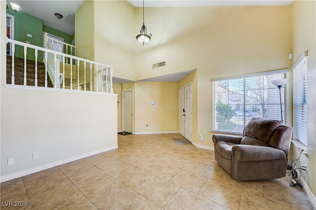 14 Barton Spring Circle Henderson, NV 89074 - Photo 9 of 64 Foyer with a towering ceiling, healthy amount of natural light, stairway, and tile patterned flooring