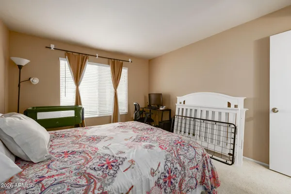 a bedroom with a bed and a large window