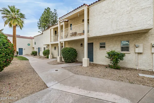 a view of a house with a yard and palm trees