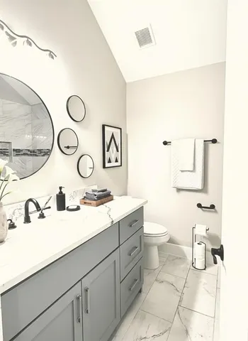 a bathroom with a double vanity sink mirror and toilet