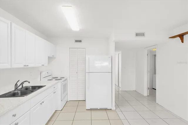 a kitchen with white cabinets and appliances