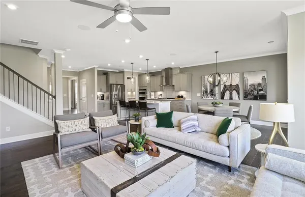 a living room with furniture kitchen view and a chandelier