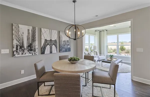a dining room with furniture a chandelier and wooden floor